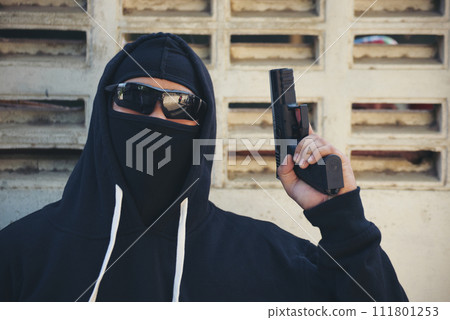 Terrorist war criminal men holding gun weapon in hand mafia attack make a crime thief in black dress medium shot. Bad anonymous soldier army. Illegal bandit murderer criminal terrorist war concept 111801253