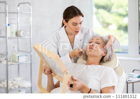 Mature patient with mirror Mature patient with mirror 111801312