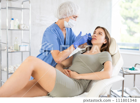 Young woman getting lip fillers. 111801348