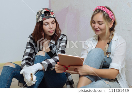 Home interior. Two cute girls designer and painter make repairs in the house.A team of decorators 111801489