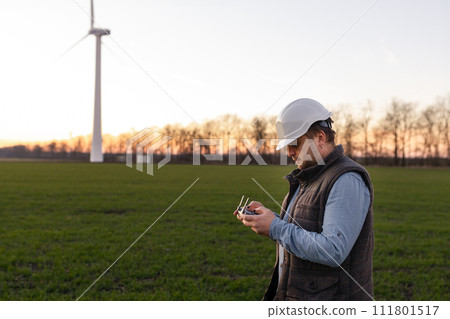 Technician Engineer in Wind Turbine Power Generator Station launches a drone for visual control of generators 111801517