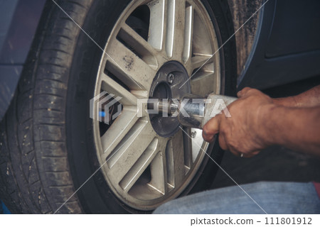 Close up Mechanic man hands repairing car auto repair shop uses jack change tyre. Man hands fixing Shock absorber machinery vehicle mechanical service. Vehicle Car overhaul maintenance engineer Close up Mechanic man hands repairing car auto repair shop uses jack change tyre. Man hands fixing Shock absorber machinery vehicle mechanical service. Vehicle Car overhaul maintenance engineer 111801912