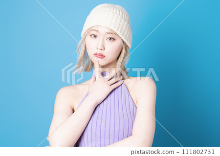 Pop makeup image of a young woman photographed against a blue background 111802731