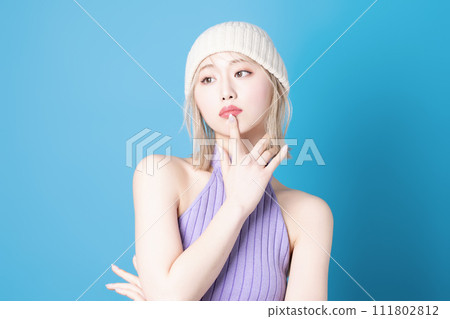 Pop makeup image of a young woman photographed against a blue background Pop makeup image of a young woman photographed against a blue background 111802812