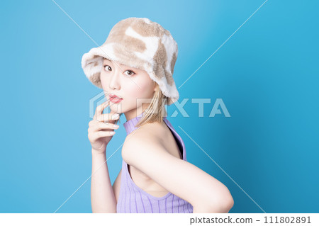 Pop makeup image of a young woman photographed against a blue background Pop makeup image of a young woman photographed against a blue background 111802891