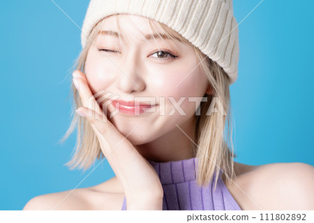 Pop makeup image of a young woman photographed against a blue background Pop makeup image of a young woman photographed against a blue background 111802892