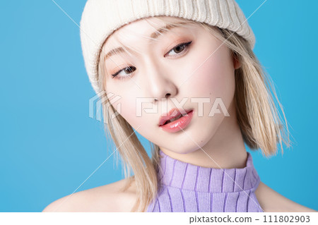 Pop makeup image of a young woman photographed against a blue background 111802903