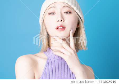 Pop makeup image of a young woman photographed against a blue background Pop makeup image of a young woman photographed against a blue background 111802949