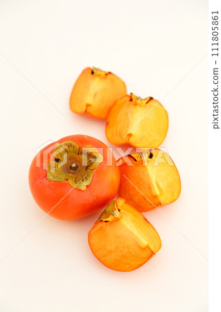 Persimmons photographed against a white background and persimmons cut into quarters Persimmons photographed against a white background and persimmons cut into quarters 111805861