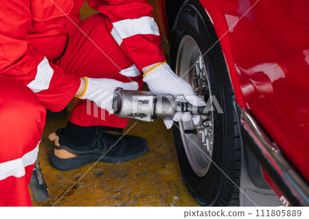 closeup garage mechanic worker replace car tyre change replace rubber wheels in auto service center concept closeup garage mechanic worker replace car tyre change replace rubber wheels in auto service center concept 111805889