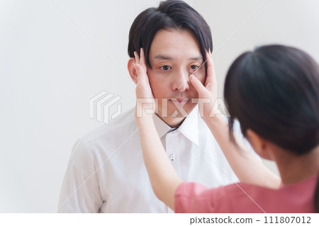 A man undergoing an eye examination at an ophthalmologist 111807012