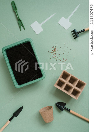 Gardening tool kit for a gardener on a green table background. The concept of spring gardening, a home hobby for the whole family 111807476