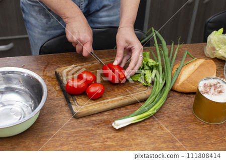 Chop the green onions and tomatoes and place them in a bowl. Prepare the salad. Chop the green onions and tomatoes and place them in a bowl. Prepare the salad. 111808414