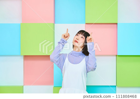 young woman pointing upwards 111808468