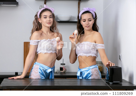 Girlfriends in the kitchen. Two beautiful girls with marshmallows. Girlfriends in the kitchen. Two beautiful girls with marshmallows. 111809269