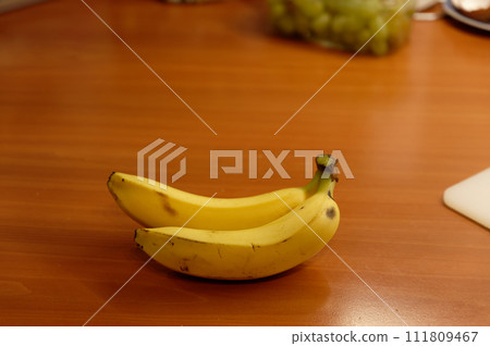 Beautiful fresh yellow banana on the table. Healthy food - fruit for a snack. Beautiful fresh yellow banana on the table. Healthy food - fruit for a snack. 111809467