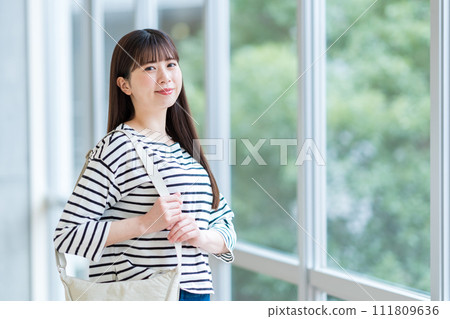 A female university student standing in the hallway. Photography cooperation: Ariake College of Education and Arts A female university student standing in the hallway. Photography cooperation: Ariake College of Education and Arts 111809636