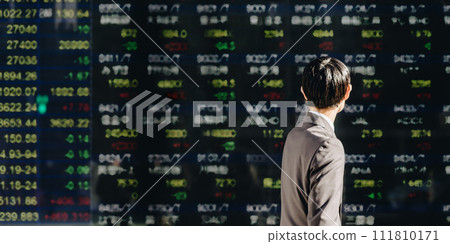 Image of a young businessman interested in stock management at NISA looking at the stock price board on an outdoor electronic bulletin board Image of a young businessman interested in stock management at NISA looking at the stock price board on an outdoor electronic bulletin board 111810171