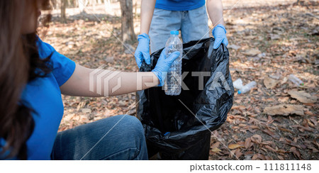 Young people friend volunteer collecting garbage plastic bottles to trash bags. environmental care ecology concept 111811148