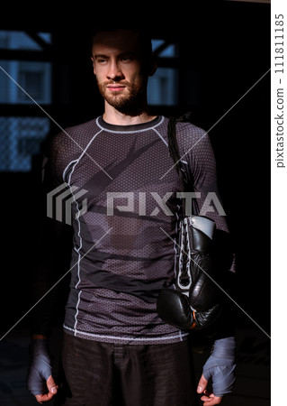 Confident relaxed fighter standing in gym after successful training 111811185