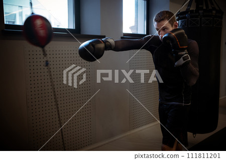 Fighter sharpening accuracy using double-end bag in boxing gym 111811201