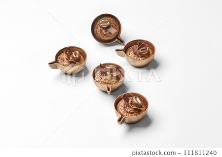 Chocolate candies in shape of miniature coffee cups on white Chocolate candies in shape of miniature coffee cups on white 111811240
