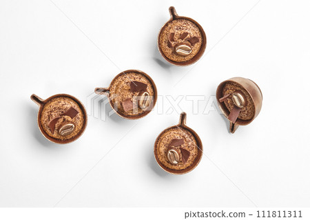Artisan chocolate coffee candies shaped as miniature cups 111811311