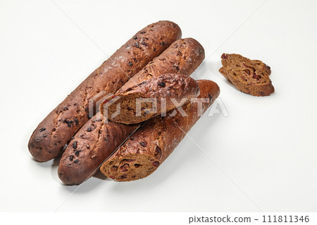 Dark rye baguettes with cranberries on white background Dark rye baguettes with cranberries on white background 111811346