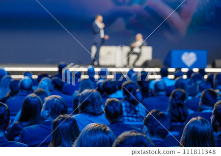 Business conference presentation with speaker on stage and audience listening 111811348
