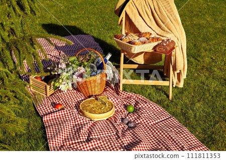 Summer picnic setup with quiche and pastries on grass Summer picnic setup with quiche and pastries on grass 111811353
