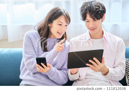 一名男子和一名女子比較智慧型手機和平板電腦螢幕 111812036