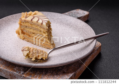 Piece of delicious sweet esterhazy cake with nuts and cream Piece of delicious sweet esterhazy cake with nuts and cream 111812244