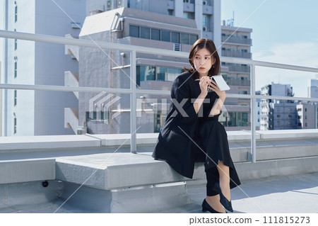 Business woman taking notes on the rooftop 111815273