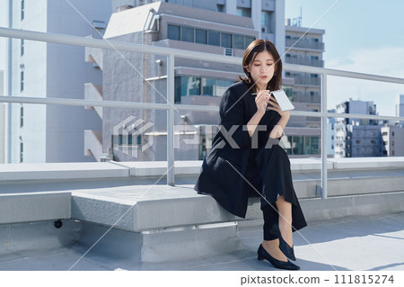 Business woman taking notes on the rooftop Business woman taking notes on the rooftop 111815274