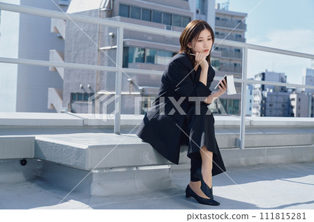 Business woman taking notes on the rooftop Business woman taking notes on the rooftop 111815281