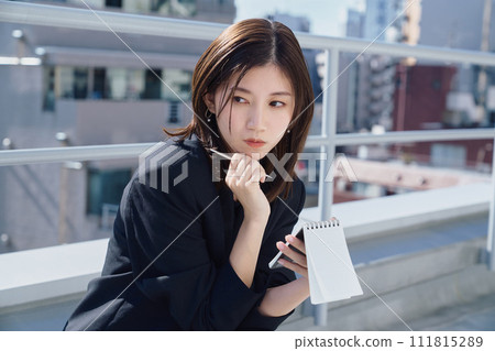 Business woman taking notes on the rooftop Business woman taking notes on the rooftop 111815289