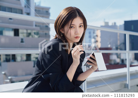 Business woman taking notes on the rooftop 111815293