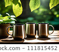 Three coffee mugs rest on a table with a plant in the background and sunshine filtering through its leaves. 111815452
