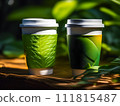 With a green leaf on the side, two take-out cups of coffee are placed on a table beside plants and foliage in the sunshine. 111815487