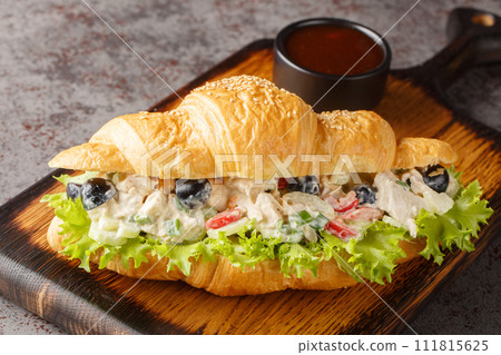 Homemade Healthy Chicken Salad Croissant Sandwich closeup on a wooden board. Horizontal Homemade Healthy Chicken Salad Croissant Sandwich closeup on a wooden board. Horizontal 111815625