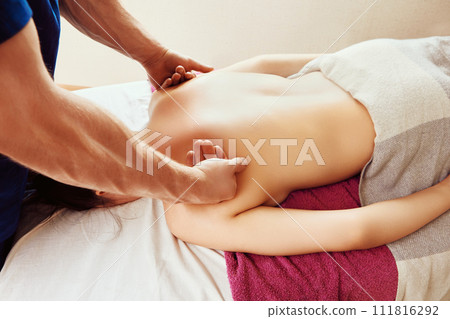 Therapeutic technique for back pain is deep tissue massage, close-up of man hands massaging woman muscles in shoulder area 111816292