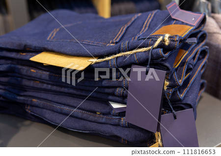 Close up denim jeans stacked in shop. Close up denim jeans stacked in shop. 111816653