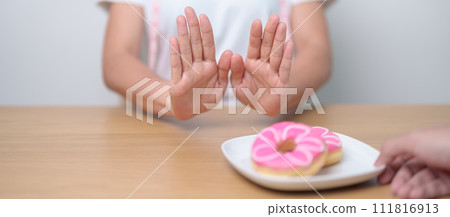 woman hand reject donut dessert, female refuse Unhealthy junk food. Dieting control, Weight loss, Obesity, eating lifestyle and nutrition concepts 111816913