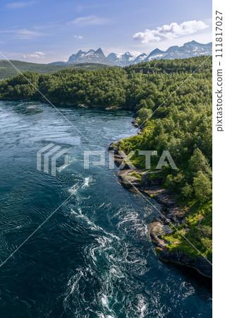 Vertical frame captures Saltstraumen tidal currents vibrant textures contrasting with lush landscape Vertical frame captures Saltstraumen tidal currents vibrant textures contrasting with lush landscape 111817027