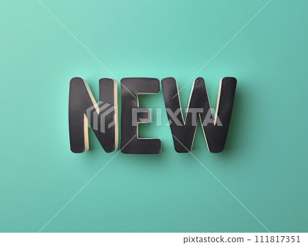 Inscription, letters on a blackboard. Phrase NEW on sticker on green background. 111817351
