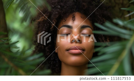 Woman meditating among green leaves 111817553