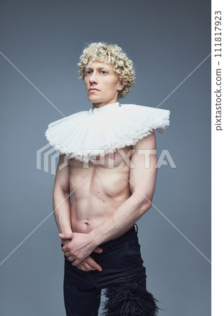 Past and present. Portrait of shirtless man with ruffled collar and black trousers against grey studio background. Past and present. Portrait of shirtless man with ruffled collar and black trousers against grey studio background. 111817923