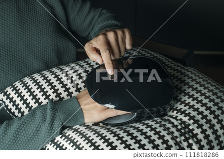 man uses a hand massager indoors 111818286