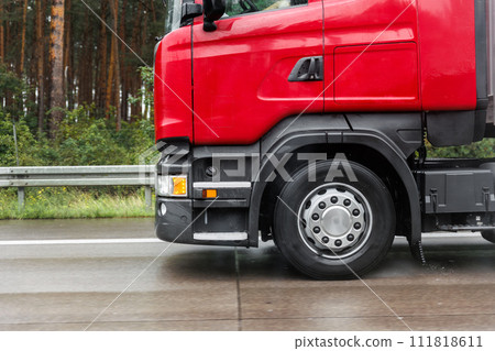 Close-up semi-trailer truck wheel driving fast Splashing Water on Highway, Risk of Aquaplaning on Wet Road. Detail view of hydroplane danger on rainy asphalt surface. Weather conditions. Close-up semi-trailer truck wheel driving fast Splashing Water on Highway, Risk of Aquaplaning on Wet Road. Detail view of hydroplane danger on rainy asphalt surface. Weather conditions. 111818611