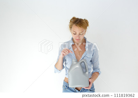 Woman holding canister of motor oil on light background Woman holding canister of motor oil on light background 111819362